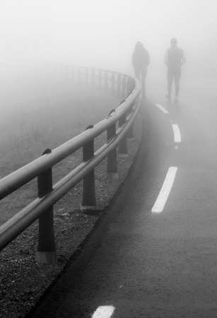 girl and guy on the road fogの写真素材