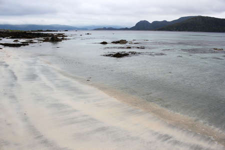 beach near the ocean on a cloudy day with mountain viewsの写真素材