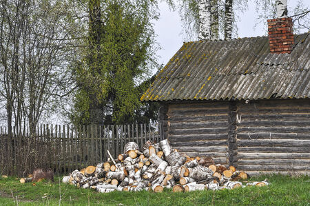 Old russian village house with a bundle of firewoodの写真素材