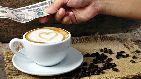 Love cappuccino coffee with hearts. A cup of latte, cappuccino or espresso coffee with milk put on a wood table with dark roasting coffee beans. Drawing the foam milk on top.の写真素材