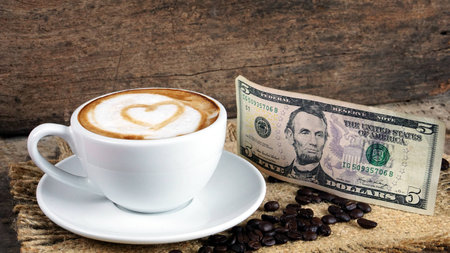 Cappuccino Coffee. A cup of latte, cappuccino or espresso coffee with milk put on a wood table with dark roasting coffee beans. Drawing the foam milk on top.の写真素材