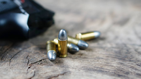 Bullets and a firearm on the wood. Bullets are a projectile expelled from the barrel of a firearm.の写真素材
