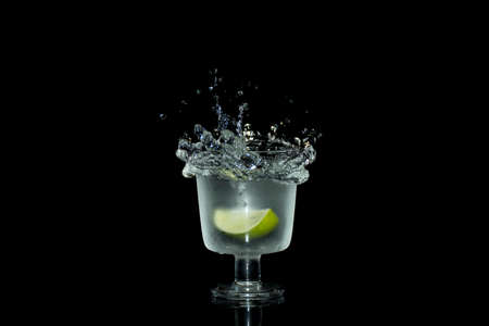 Water splash, lime in glass on black backgroundの写真素材