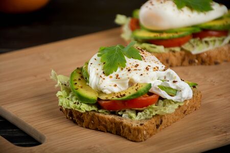 Healthy sandwiches for the breakfast with avocado and poached eggの写真素材