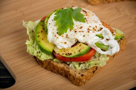Healthy sandwiches for the breakfast with avocado and poached eggの写真素材