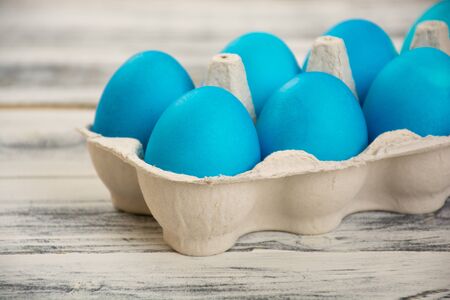 Blue easter eggs in egg box on wooden tableの写真素材