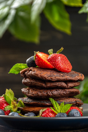 Chocolate pancakes with berries, strawberries, blueberries, good choice for breakfast, veganの写真素材