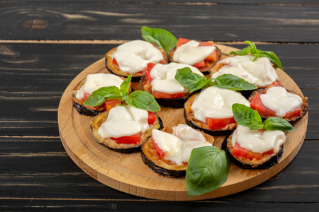 Mini eggplant pizza with mozzarella cheese, tomatoes and basilの写真素材