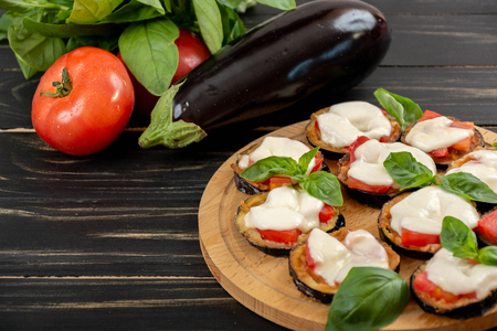Mini eggplant pizza with mozzarella cheese, tomatoes and basilの写真素材