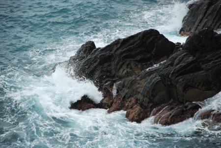 Wave breaking against cliff in Cinque Terre, Italyの写真素材