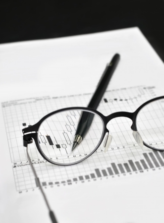 Stock market charts, eyeglasses, and machanical pencilの写真素材