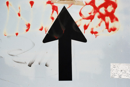 Old road sign with arrow pointing upの写真素材