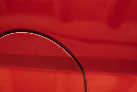 part of close gasoline cap cover on red automobileの写真素材