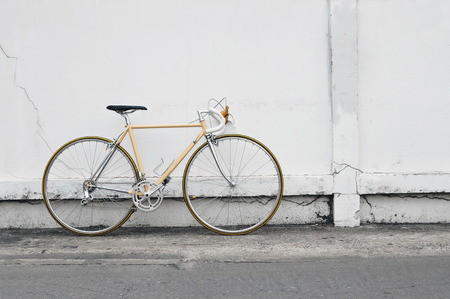 Vintage road bicycle leaning on white wallの写真素材