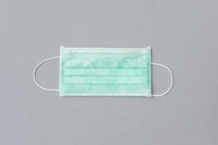 Still life of am unused green face mask on gray backgroundの写真素材