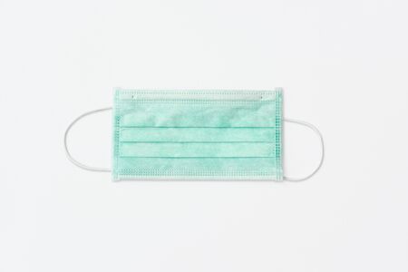 Still life of am unused green face mask on white backgroundの写真素材