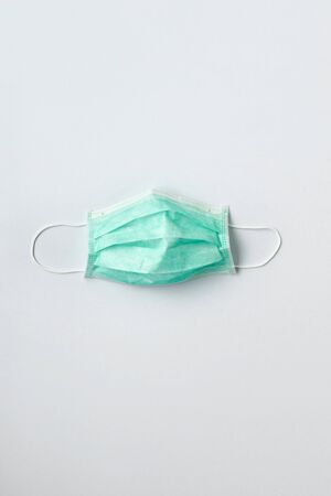 Still life of am unused green face mask on white backgroundの写真素材