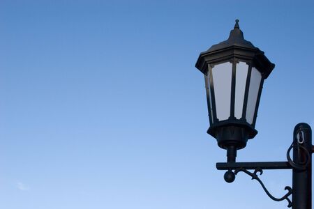 A classic lamp post against an isolated blue sky for design workの写真素材