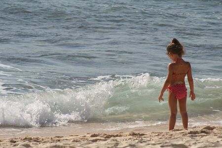 A young girl playing on a beach.の写真素材