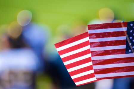 American flag flown at Football game with focus on flagの写真素材