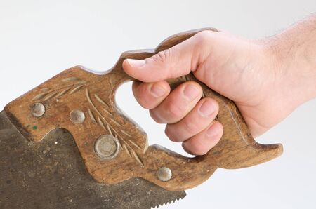 A hand holding a sawの写真素材