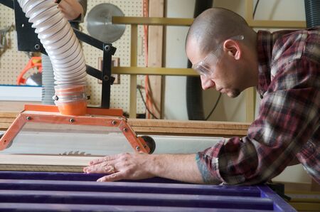 Woodworker working on table sawの写真素材