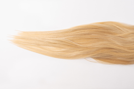 Human, natural light blond straight hair on white isolated background. An example of a fashionable hairstyle for a poster or an hairdressing website.の写真素材