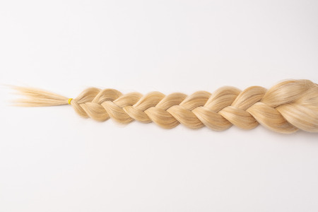 Human, natural light blond hair tress on white isolated background. An example of a fashionable hairstyle for a poster or an hairdressing website.の写真素材