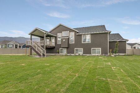 Rear exterior of large home with huge grass lawnの写真素材
