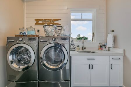 Beautiful white cabinets and large washer and dryer in laundry roomの写真素材