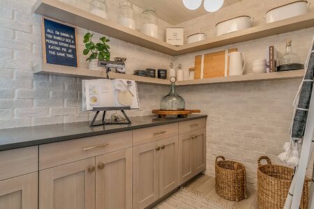 Large beautifully decorated pantry with white brick walls