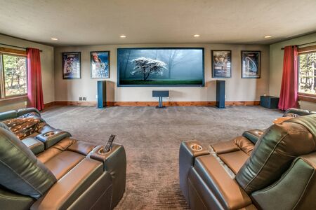 Theater room with large projection screen and plenty of seating for a crowd