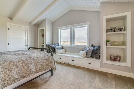 Beautiful bedroom with window bench and built in shelvingの写真素材