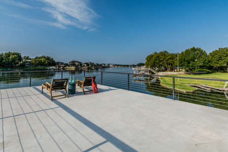 Deck platform and covered patio of Texas home near a lake, with outdoor entertaining options