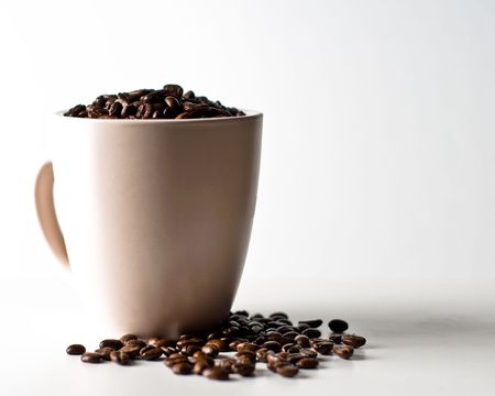 whole bean coffee in mug isolated on whiteの写真素材