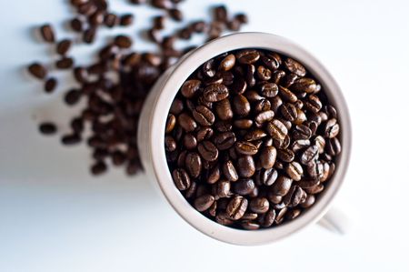 whole bean coffee in mug isolated on whiteの写真素材