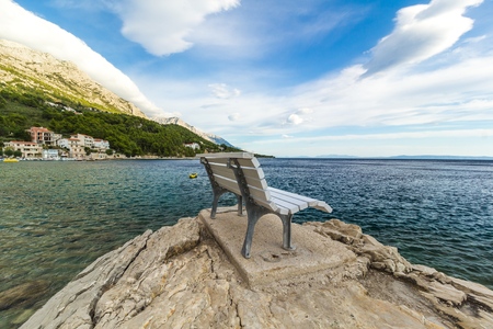 Empty bench by the mediterranean sea, beautiful landscapeの写真素材