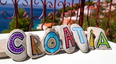 croatia word written on the painted stones, dalmatian city in the backgroundの写真素材