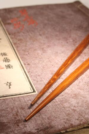 Old Japanese book from meiji period with chopsticks and japanese maple leafの写真素材