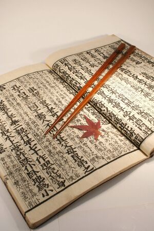 Old Japanese book from meiji period with chopsticks and japanese maple leafの写真素材