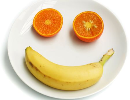 A smiling happy fruit face on a white plateの写真素材