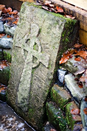 Old stone cross by a natural spring.の写真素材