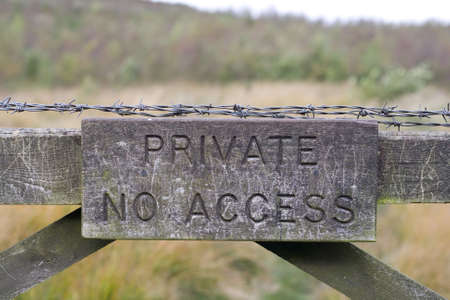Private No Access sign on wooden gate with barbed wire.の写真素材