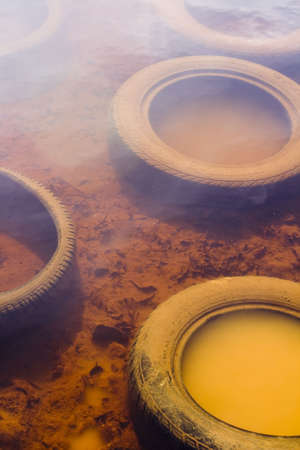Dumped Tyres in the water of a reservoirの写真素材