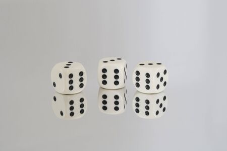 Three White dice with Black spots, all the 6's, and reflections.