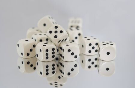 Multiple White dice with Black spots and reflections.