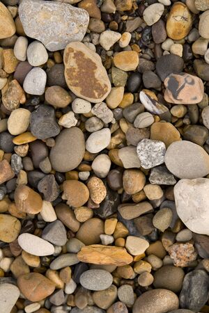 Seaside gravel and pebbles on the beach, beach background.
