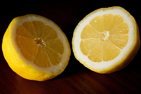 A lemon cut in half, exposing both sides on a tableの写真素材
