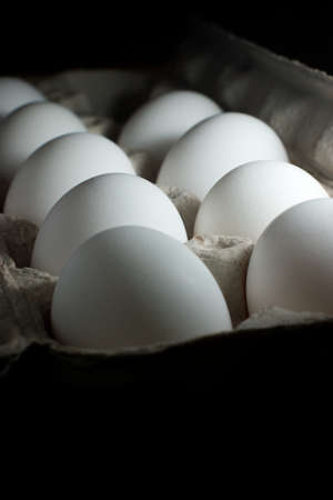 Eggs in a carton on a black backgroundの写真素材
