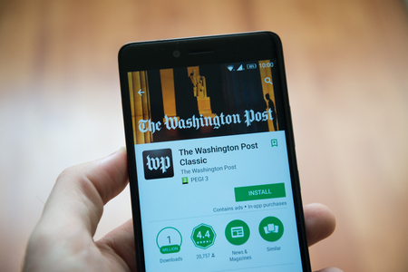 Los Angeles, november 2, 2017: Man hand holding smartphone with The Washington post application in google play storeのeditorial素材